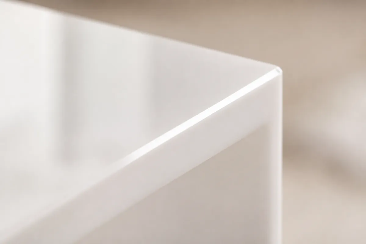 Cận cảnh góc vát của tấm mica trắng bóng, bề mặt nhẵn phản chiếu ánh sáng dịu